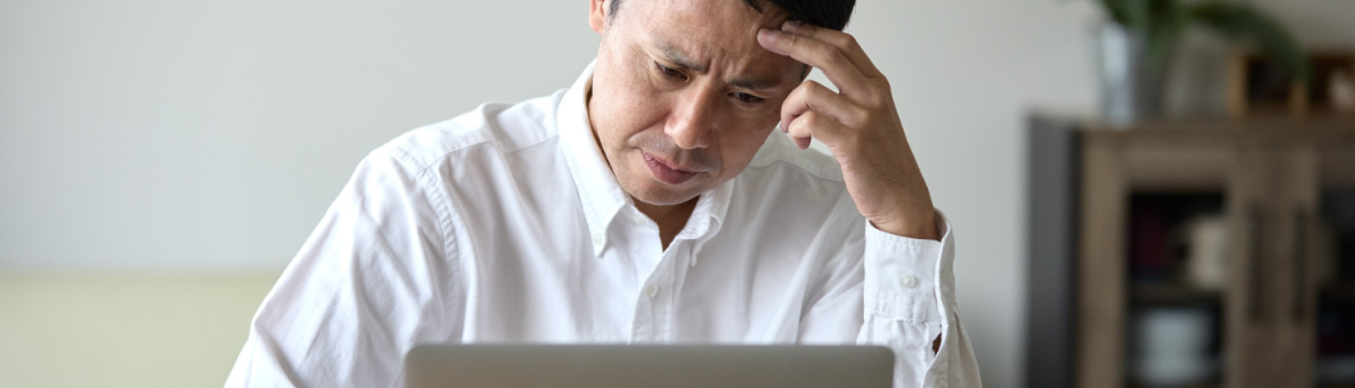 Person sat at their desk looking stressed with head in hands