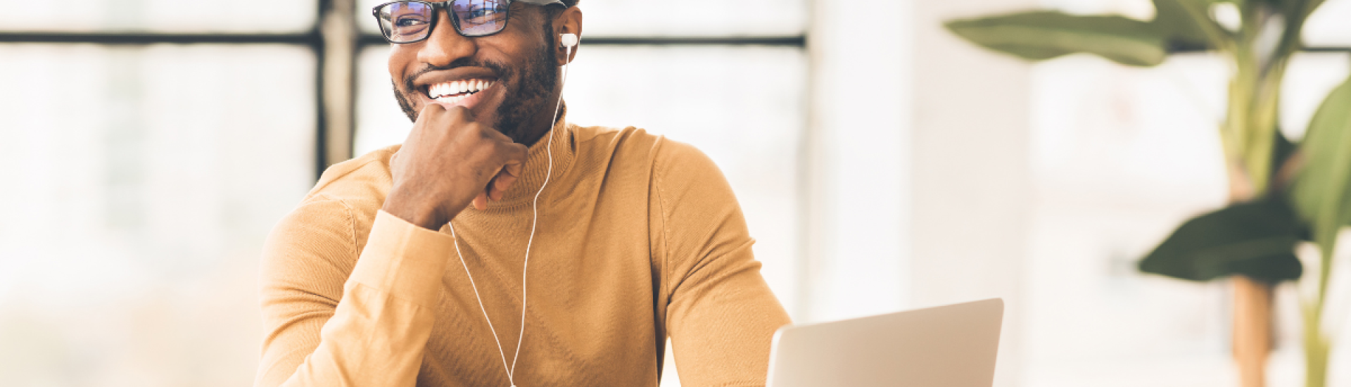 Man with glasses smiling at his work desk
