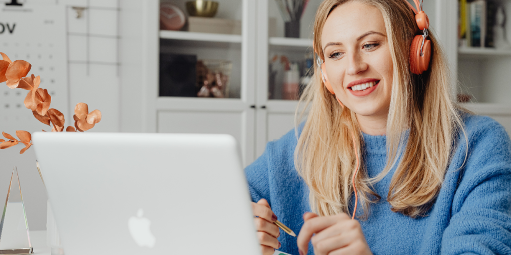 Woman wearing headphones on video call with team