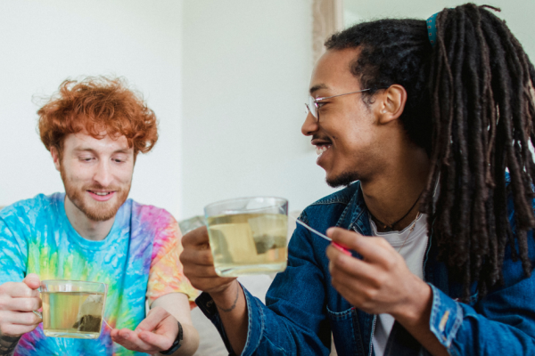 Photo of two young men talking and drinking tea