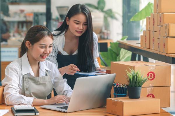 Two ladies looking at a laptop in a boxing/plant business
