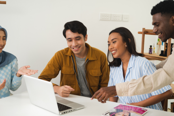 Group of people around a laptop