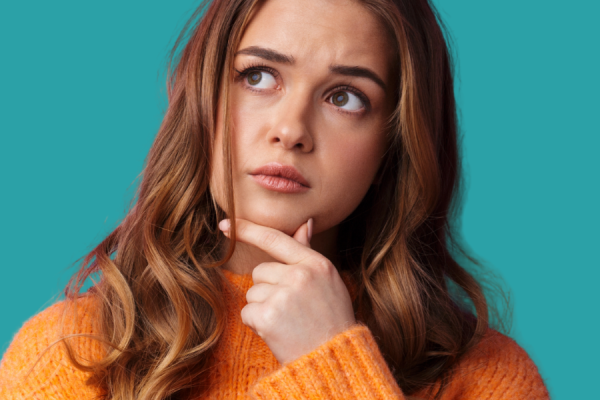 Woman with her hand holding her chin in a thinking pose 