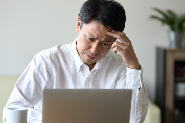 Person sat at their desk looking stressed with head in hands